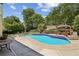 An in-ground pool surrounded by a beautifully landscaped backyard with mature trees at 5605 Preserve Cir, Johns Creek, GA 30005