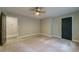 Spacious bedroom with neutral walls, carpet, ceiling fan, and two large doors at 1329 Hidden Hills Pkwy, Stone Mountain, GA 30088