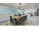 Open-concept dining room with natural light, modern lighting, and views into the kitchen and backyard at 1329 Hidden Hills Pkwy, Stone Mountain, GA 30088