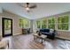 Bright living room with large windows, ceiling fan, new flooring, and access to the outdoor deck at 1329 Hidden Hills Pkwy, Stone Mountain, GA 30088