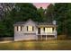 Exterior of home showcasing front porch, a large grassy yard, and mature trees at 148 White Pine Ln, Temple, GA 30179