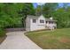 Home exterior showing the driveway, lawn, and mature trees around the property at 148 White Pine Ln, Temple, GA 30179