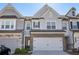 Charming townhome with a two-car garage and landscaped front yard with brick and grey shingle facade at 2946 Stockholm Way, Suwanee, GA 30024