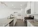 Bright kitchen features granite counters, stainless steel appliances, white cabinets and wooden floors at 2946 Stockholm Way, Suwanee, GA 30024