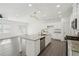 Open kitchen with granite counters, island with sink and stainless-steel appliances, flowing into the living area at 2946 Stockholm Way, Suwanee, GA 30024