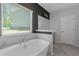 Bright bathroom featuring a soaking tub, marble accents, and a view of the outdoors at 420 Tavistock Ct, Mcdonough, GA 30252