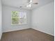 Simple bedroom with neutral carpet, window, and a ceiling fan at 3656 Oak Sw Ln, Powder Springs, GA 30127