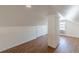Bright attic space with wood laminate flooring, a window and a white brick pillar at 1560 Temple Ave, College Park, GA 30337