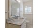 Bathroom vanity with marble countertop, large mirror, and shuttered window at 1560 Temple Ave, College Park, GA 30337