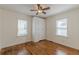 Neutral bedroom featuring a ceiling fan, hardwood floors, two windows and built in storage at 1560 Temple Ave, College Park, GA 30337