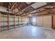 Spacious garage interior featuring a concrete floor, block walls, exposed rafters, and wood shelving at 1560 Temple Ave, College Park, GA 30337