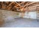 Spacious garage interior featuring a concrete floor, block walls, exposed rafters and shelving at 1560 Temple Ave, College Park, GA 30337