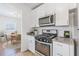 Efficient kitchen with white cabinets, stainless steel appliances, and adjacent dining area at 1560 Temple Ave, College Park, GA 30337