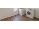 Well-lit laundry room with wood floors, modern washer and dryer, and a window at 1560 Temple Ave, College Park, GA 30337