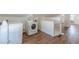 Spacious laundry area in an upstairs bonus room featuring modern appliances and wood floors at 1560 Temple Ave, College Park, GA 30337
