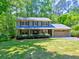 Charming two-story home with a lush front lawn and mature trees, featuring a welcoming covered porch at 351 Ridgewater Dr, Marietta, GA 30068