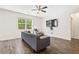 Bright living room featuring wood floors, a ceiling fan, a window, and a modern gray sofa at 1196 Erica Se Way, Atlanta, GA 30354