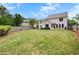 Expansive backyard with a lush green lawn, enclosed by a wooden fence, with a clear view of the home's rear exterior at 135 Haleys Cir, Woodstock, GA 30188