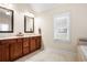 Bathroom featuring double sink vanity, tile flooring, and bright natural light from window with custom blinds at 135 Haleys Cir, Woodstock, GA 30188