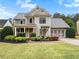 Charming two-story home with gray siding, a landscaped yard, and an attached two-car garage at 135 Haleys Cir, Woodstock, GA 30188