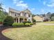 Well-manicured front yard with lush green grass and tasteful landscaping around a gray two-story home at 135 Haleys Cir, Woodstock, GA 30188