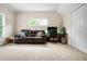 A versatile living room with plush carpet, large windows, and a comfortable leather sofa for relaxation and entertainment at 135 Haleys Cir, Woodstock, GA 30188