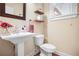 Stylish half-bathroom featuring pedestal sink, wood floors, and elegant fixtures at 135 Haleys Cir, Woodstock, GA 30188