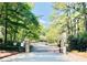 Stone gated entrance surrounded by lush trees, offering security and privacy to this charming neighborhood at 2007 Wingate Way, Atlanta, GA 30350
