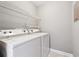 Functional laundry room with washer, dryer, and shelving for storage at 2007 Wingate Way, Atlanta, GA 30350