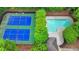 Aerial view of a tennis court, pool, and surrounding greenery offers luxurious outdoor recreation at 3045 Wyntree Dr, Peachtree Corners, GA 30071