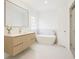 Modern bathroom with white tile, a wooden vanity, and a large soaking tub at 3045 Wyntree Dr, Peachtree Corners, GA 30071