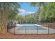 A calming shot of the community pool surrounded by lush trees and a dark fence at 3045 Wyntree Dr, Peachtree Corners, GA 30071