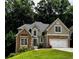 Charming two-story home with a stone and stucco facade, lush lawn, and attached two car garage at 3045 Wyntree Dr, Peachtree Corners, GA 30071