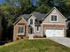 Charming two-story home features stone accents, a two-car garage, and a well-maintained lawn at 3045 Wyntree Dr, Peachtree Corners, GA 30071
