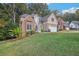 Lovely two-story home with stone details, a two-car garage, and lush green lawn at 3045 Wyntree Dr, Peachtree Corners, GA 30071