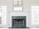 Close-up of a fireplace with a green marble surround and white mantel, flanked by windows at 3045 Wyntree Dr, Peachtree Corners, GA 30071