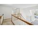 Hallway with a dark wood railing overlooking a living room with a chandelier at 3045 Wyntree Dr, Peachtree Corners, GA 30071