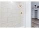 Bathroom shower stall featuring white marbled tile and gold hardware at 4269 Indian Forest Trl, Stone Mountain, GA 30083