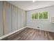 Bedroom featuring hardwood floors, modern wall accent, neutral paint, and a view to the backyard at 4269 Indian Forest Trl, Stone Mountain, GA 30083