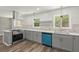 Modern kitchen featuring stainless steel appliances, gray cabinets, quartz counters, and hardwood floors at 4269 Indian Forest Trl, Stone Mountain, GA 30083