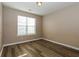 Cozy bedroom with a window providing natural light, complemented by modern wood-look flooring at 1501 Buckingham Pl, Stockbridge, GA 30281