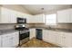 Modern kitchen with white cabinets, granite countertops, and stainless steel appliances at 1501 Buckingham Pl, Stockbridge, GA 30281