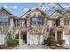 Charming brick townhome featuring an attached garage, front yard landscaping, and inviting front entrance at 2872 Cross Creek Ct, Cumming, GA 30040