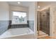 Bright bathroom featuring a glass shower, window over a soaking tub, and tile flooring at 40 Begonia Ct, Covington, GA 30016