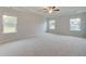 Large bedroom with carpet, tray ceiling, ceiling fan, and windows providing ample natural light at 40 Begonia Ct, Covington, GA 30016