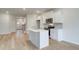 Modern kitchen with white cabinets, stainless steel appliances, island with sink, and light wood flooring at 40 Begonia Ct, Covington, GA 30016