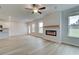 Open-concept living area features a fireplace, ceiling fan, light wood floors, and backyard access at 40 Begonia Ct, Covington, GA 30016