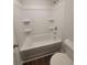 Clean, well-lit bathroom with a combined tub and shower and shelving at 558 Fairview Oak Place, Dallas, GA 30157