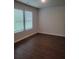 Bedroom with dark wood-look flooring, neutral paint, and two windows offering natural light and green views at 558 Fairview Oak Place, Dallas, GA 30157