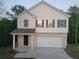Two-story home with brick accents, covered entry, asphalt shingles, attached two-car garage, and landscaped lawn at 558 Fairview Oak Place, Dallas, GA 30157